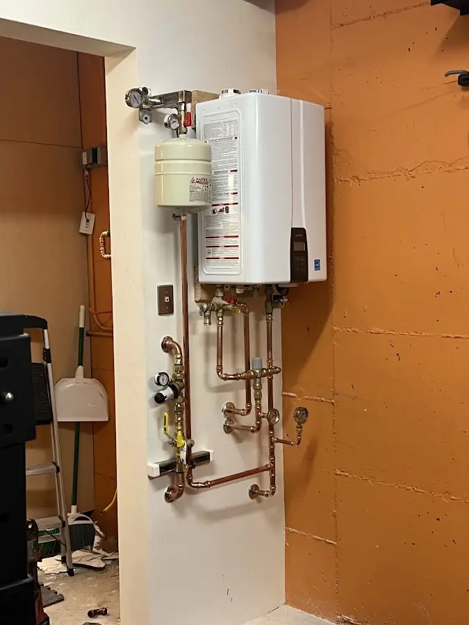 Plumbing technician inspecting water heater connections in Newcastle